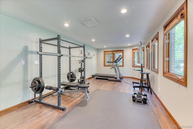 exercise room featuring wood finished floors, recessed lighting, and baseboards