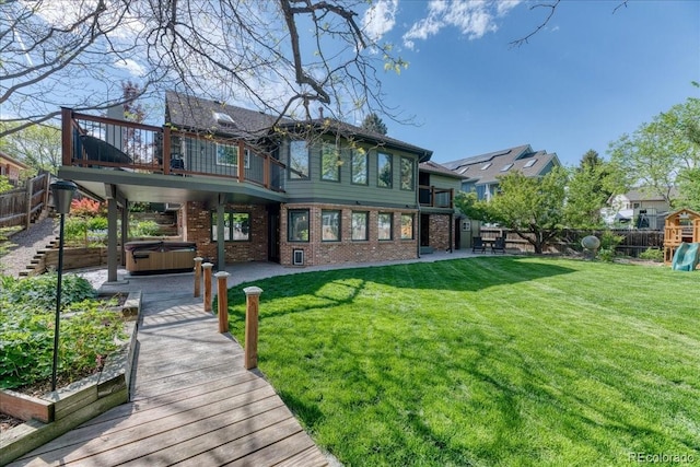 rear view of house featuring a hot tub, brick siding, a patio, and a balcony