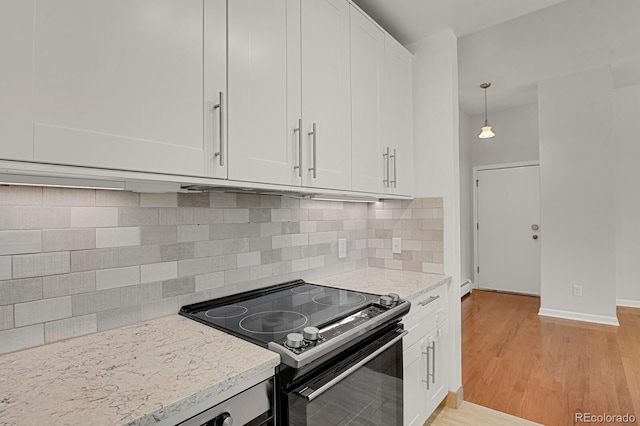 505 E 24th St Unit 204, Denver, CO 80205 - kitchen with electric range oven, white cabinets, light wood-style flooring, and backsplash