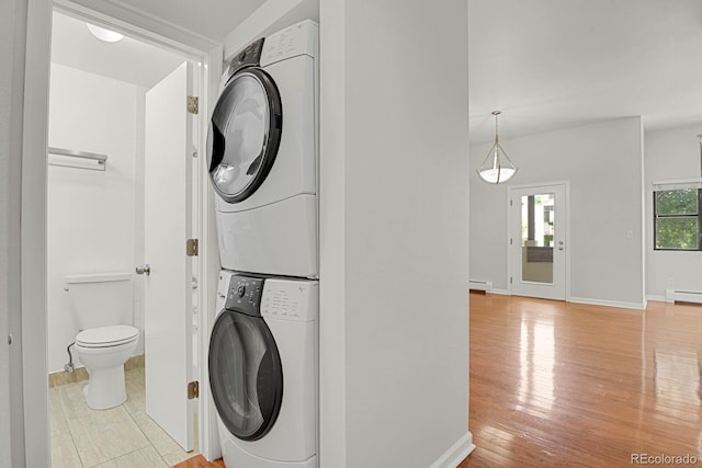 505 E 24th St Unit 204, Denver, CO 80205 - laundry area with stacked washer / drying machine, light wood-style floors, a baseboard heating unit, and baseboard heating