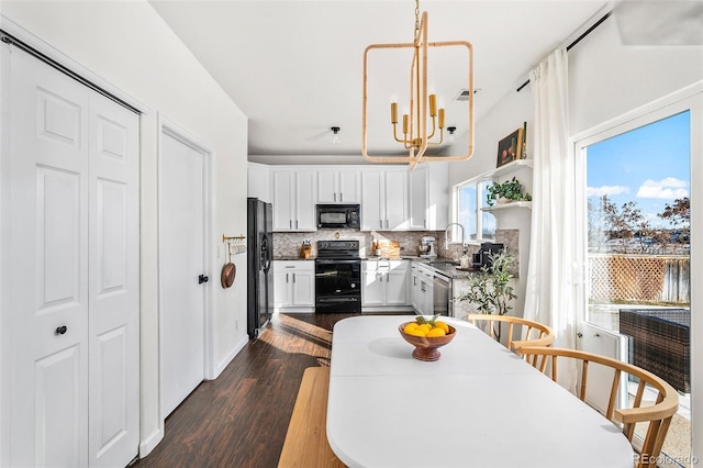 kitchen featuring black appliances, dark wood-type flooring, white cabinetry, tasteful backsplash, and an inviting chandelier