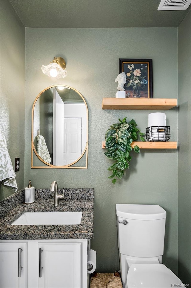 bathroom featuring toilet and vanity