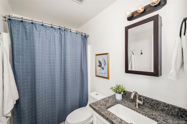 bathroom featuring walk in shower, vanity, and toilet