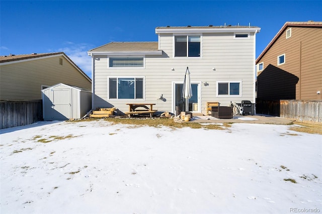 snow covered house featuring a storage shed