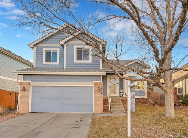 view of front of house featuring driveway, a garage, a shingled roof, fence, and brick siding