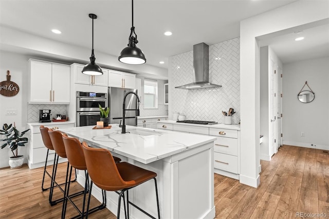 9391 E 59th N Pl, Denver, CO 80238 - kitchen with wall chimney range hood, stainless steel appliances, recessed lighting, backsplash, and light wood finished floors