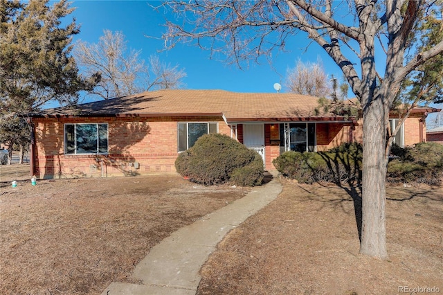 single story home featuring brick siding