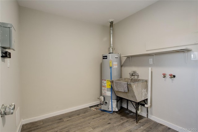 utility room featuring gas water heater and a sink