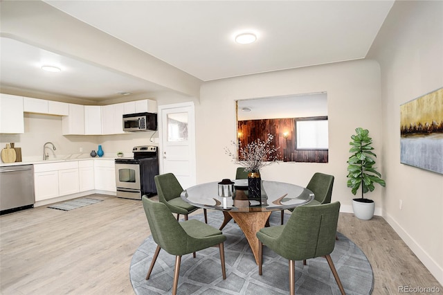 dining room featuring light wood-type flooring and baseboards