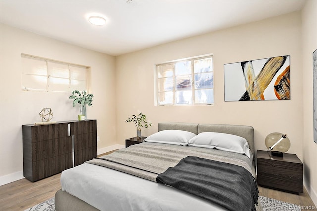 bedroom with light wood-type flooring and baseboards