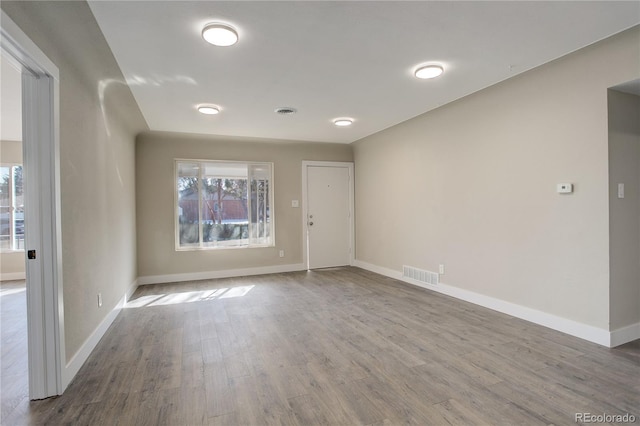 empty room featuring visible vents, baseboards, and wood finished floors