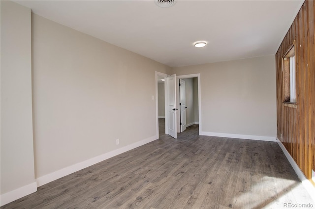 unfurnished bedroom with wood finished floors, visible vents, and baseboards