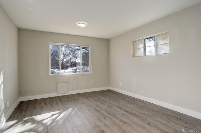 unfurnished room featuring baseboards and wood finished floors