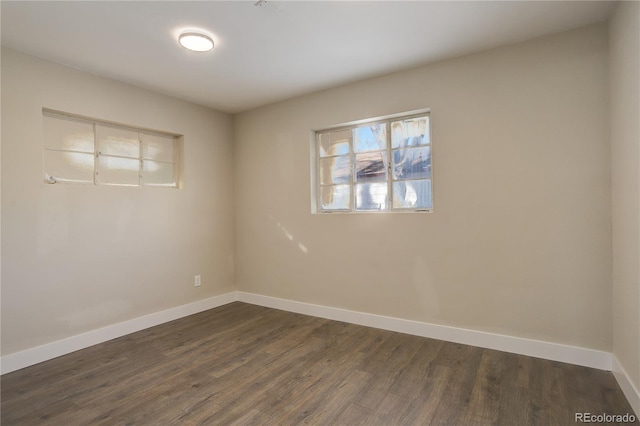 empty room featuring dark wood-style floors and baseboards