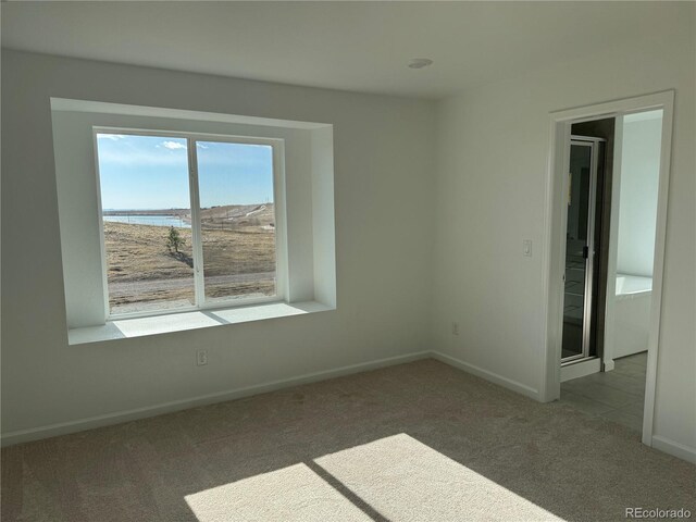 carpeted spare room with a water view