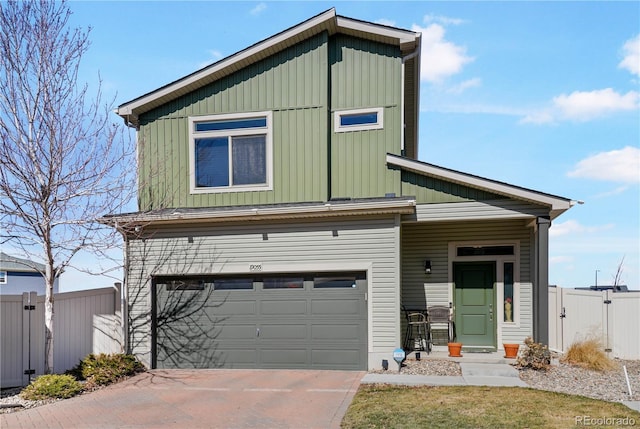 view of front of house with a garage, concrete driveway, board and batten siding, and fence