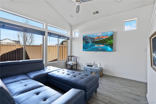 living area with ceiling fan, high vaulted ceiling, wood finished floors, visible vents, and baseboards