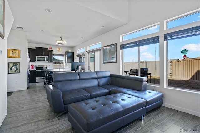 living room featuring dark wood-style flooring, recessed lighting, visible vents, and baseboards