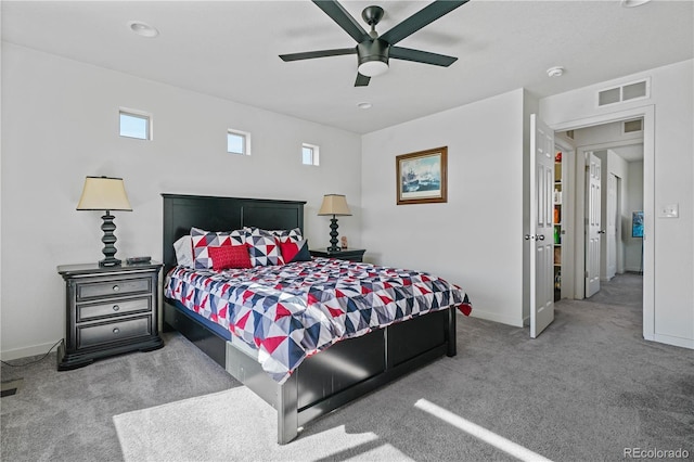 carpeted bedroom featuring a ceiling fan, visible vents, and baseboards