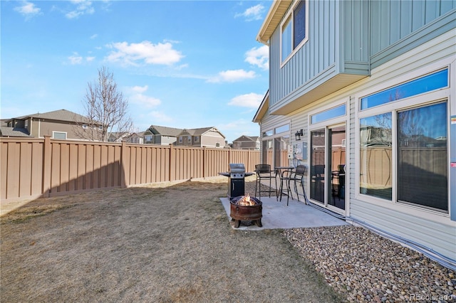 view of yard featuring a residential view, a fenced backyard, a patio, and a fire pit