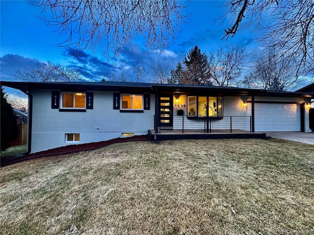 view of front of home featuring brick siding, a porch, concrete driveway, a garage, and a front lawn