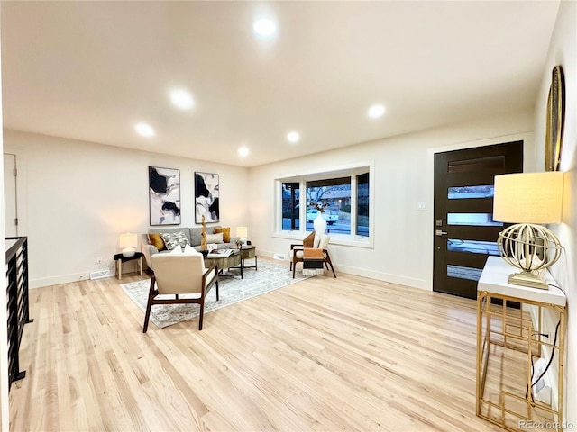 living area featuring baseboards, recessed lighting, and light wood-style floors