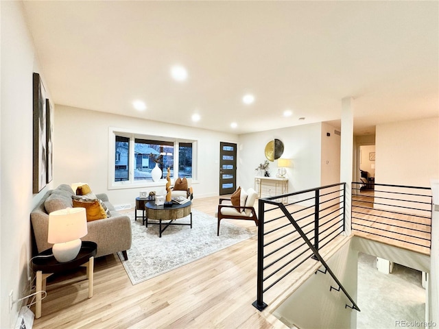 interior space with recessed lighting, baseboards, light wood finished floors, and an upstairs landing