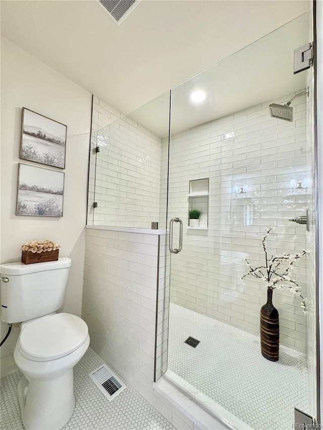 full bathroom with toilet, tile patterned flooring, visible vents, and a shower stall