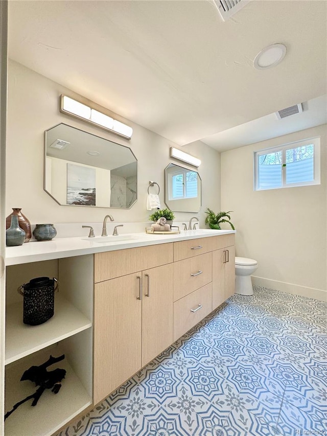 bathroom with a healthy amount of sunlight, visible vents, toilet, and a sink