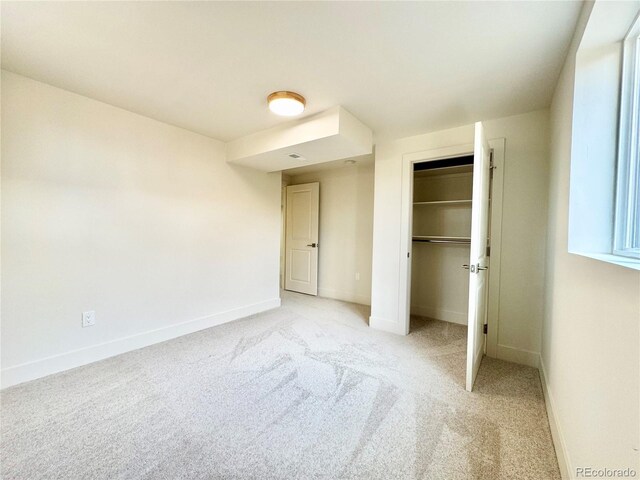 unfurnished bedroom with baseboards, a closet, and light colored carpet