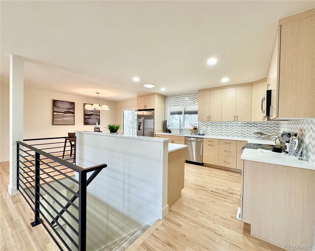 kitchen featuring light brown cabinetry, appliances with stainless steel finishes, light countertops, and light wood-style flooring