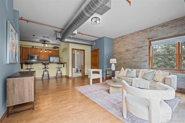 3299 Lowell Blvd Unit 204, Denver, CO 80211 - living room featuring light wood finished floors and brick wall