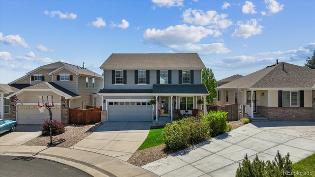11866 High Desert Rd, Parker, CO 80134 - traditional home with concrete driveway, covered porch, an attached garage, and brick siding