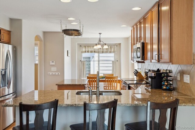 11866 High Desert Rd, Parker, CO 80134 - kitchen featuring stainless steel appliances, a sink, plenty of natural light, brown cabinetry, and recessed lighting