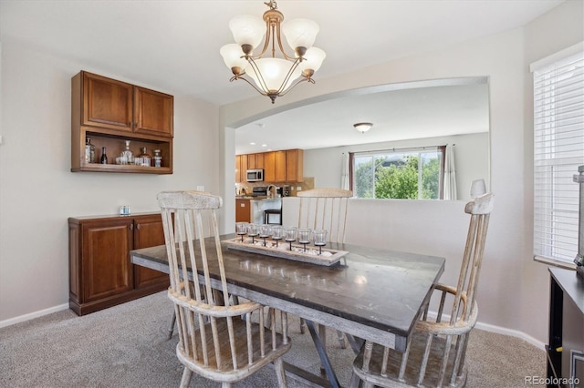 11866 High Desert Rd, Parker, CO 80134 - dining area featuring arched walkways, light colored carpet, baseboards, and a chandelier