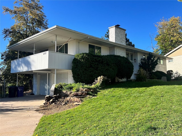 view of front of property featuring a balcony, a front lawn, and a garage