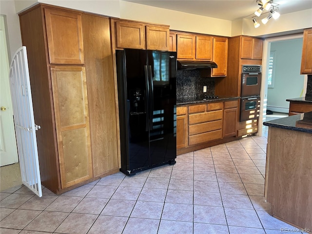 kitchen featuring black appliances, dark stone counters, light tile patterned floors, and tasteful backsplash