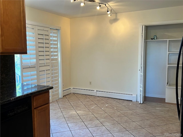 unfurnished dining area featuring a baseboard heating unit and light tile patterned floors