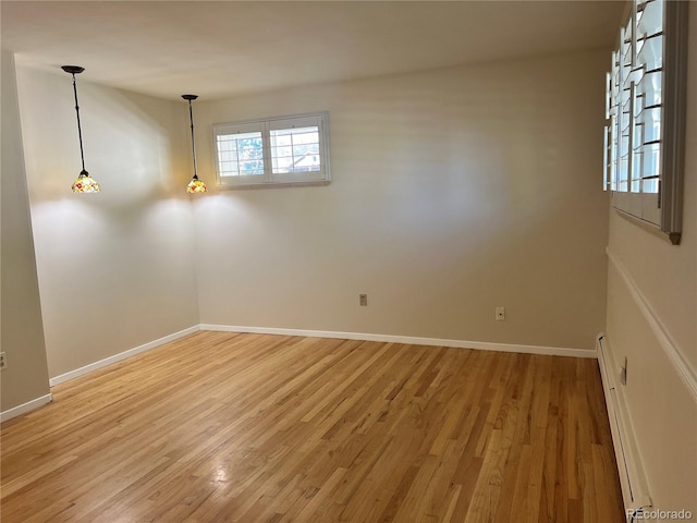 empty room with a baseboard heating unit and wood-type flooring