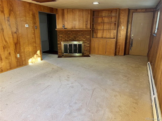 unfurnished living room with a baseboard heating unit, a fireplace, light colored carpet, and wood walls