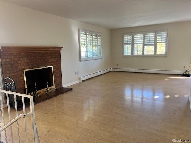 2789 S Ivan Way, Denver, CO 80227 - unfurnished living room with wood finished floors, a brick fireplace, and baseboard heating