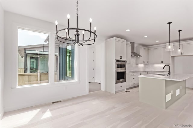5608 Grandville Ave, Longmont, CO 80503 - kitchen featuring wall chimney range hood, stainless steel double oven, hanging light fixtures, recessed lighting, and a chandelier