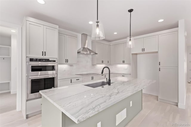 5608 Grandville Ave, Longmont, CO 80503 - kitchen featuring wall chimney exhaust hood, stainless steel double oven, recessed lighting, light stone counters, and hanging light fixtures