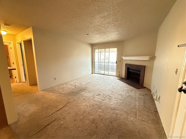 unfurnished living room featuring a fireplace, a textured ceiling, and carpet