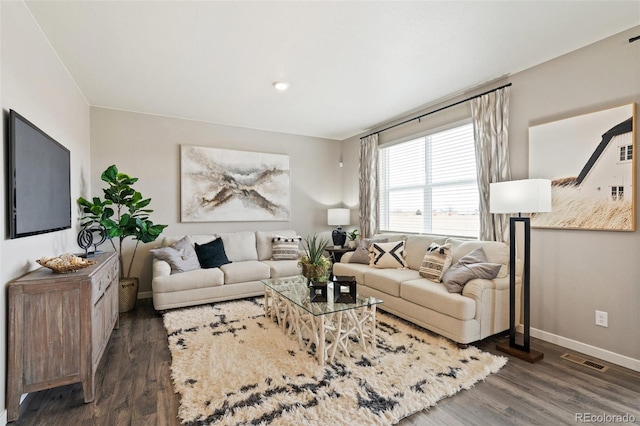 living area featuring dark wood-style floors, visible vents, and baseboards