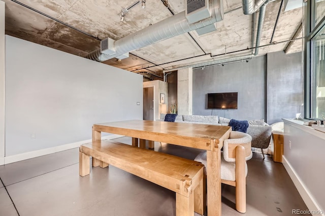 dining space featuring baseboards and finished concrete floors