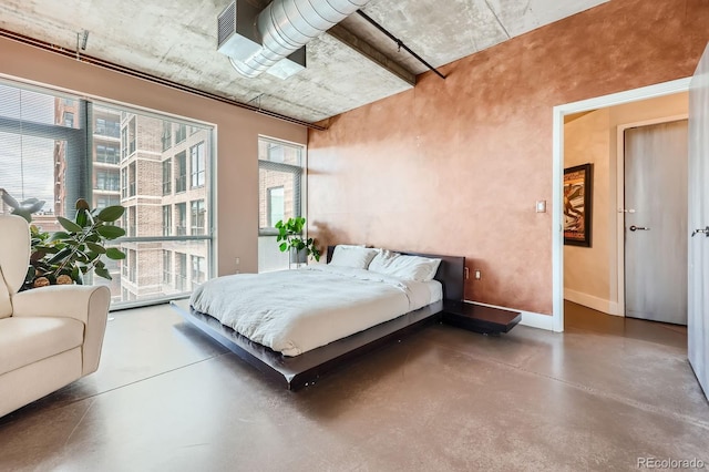 bedroom featuring concrete floors and baseboards