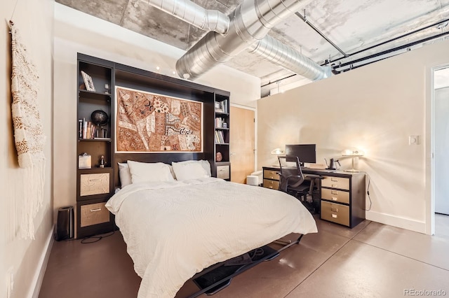 bedroom with concrete floors and baseboards