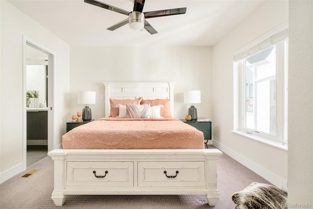 bedroom with visible vents, a ceiling fan, light carpet, connected bathroom, and baseboards