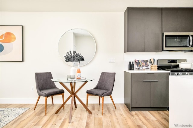 dining area with light wood-type flooring and baseboards